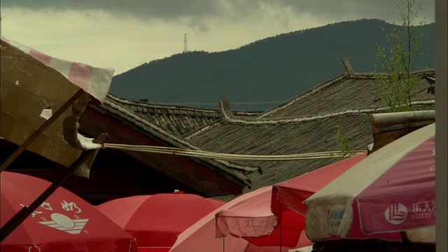 中国云南丽江中意户外市场，传统中式屋顶从遮阳伞上升起视频素材