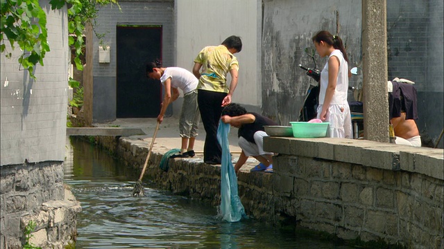 在中国山东济南的老城，人们在小溪中洗衣服视频素材