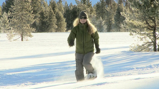 穿着雪鞋的女人在雪地里奔跑/美国爱达荷州布莱恩县视频素材