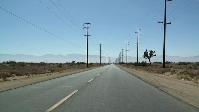 车辆行驶在沙漠公路，电话线杆/棕榈谷，美国加州视频素材