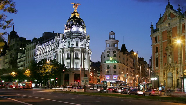 西班牙马德里，Gran Via和Calle de Alcala街角的Edificio Metropolis从黄昏到夜晚的交通封锁镜头视频素材