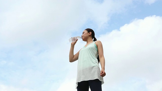 饮用瓶装水的年轻女子/涩谷，东京，日本视频素材