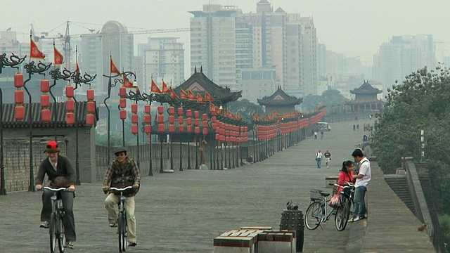 WS城墙延伸到远处，两旁挂着灯笼，骑自行车的人/西安，山西，中国视频素材