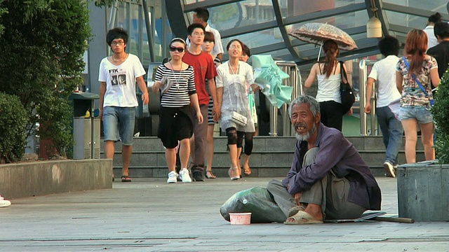 无家可归的人坐在人行道上/中国浙江宁波视频素材