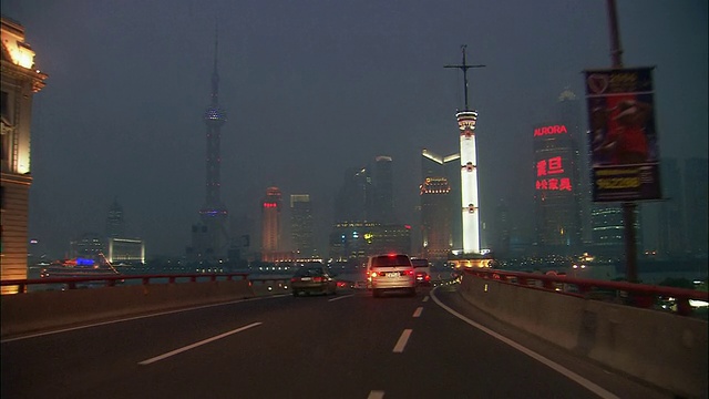 高速宽镜头驾驶视角通过浦东天际线在夜间/接近外滩/上海高速公路视频素材