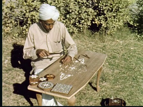 1960蒙太奇装饰建筑覆盖马赛克。内部细节。人类在木头马赛克上制作象牙。用凿子凿桌子，用锤子敲打象牙视频素材