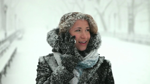 一名年轻女子在美国纽约暴风雪公园里打电话视频素材