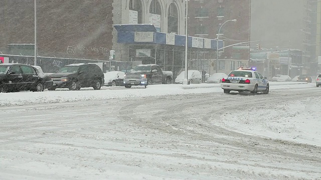 WS后视图警车缓慢地通过下雪的街道/纽约，纽约，美国视频素材