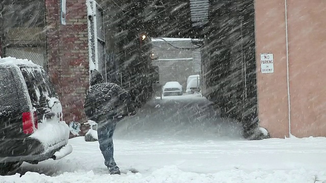 美国纽约，一名男子在暴风雪中清理车上的雪视频素材