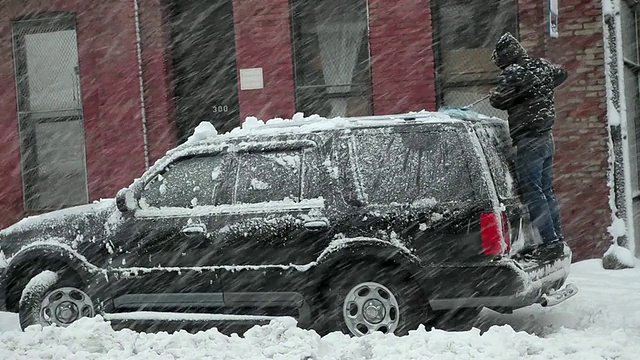 美国纽约，一名男子在暴风雪中清理车上的雪视频素材