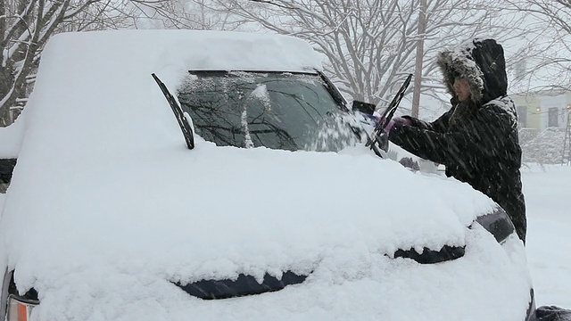 潘小姐年轻女子清理车上的雪/里士满，弗吉尼亚州，美国视频素材