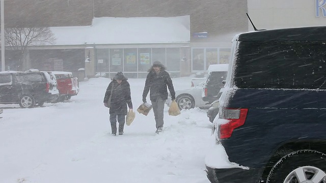 WS年轻夫妇在暴风雪中把食品杂货送到车里/里士满，弗吉尼亚州，美国视频素材