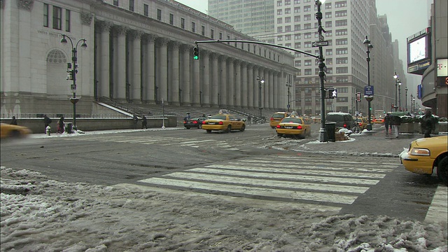 人们穿过积雪的街道，詹姆斯a法利大楼，主要的邮局大楼在纽约的背景/美国纽约视频素材