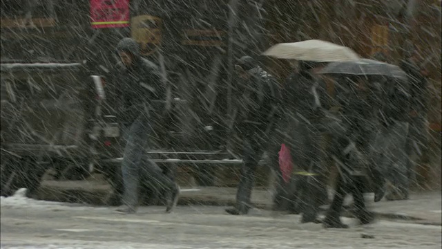 美国纽约，下雪天，穿过市中心街道的车辆和行人视频素材