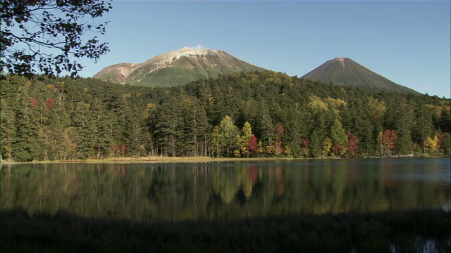 宁静的湖水被森林包围，背景是火山山脉/札幌，北海道，日本视频素材