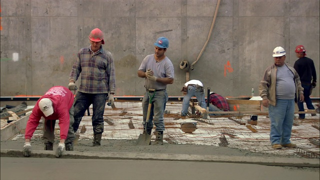 纽约市布莱恩特公园建筑工地的建筑工人正在铲水泥视频素材