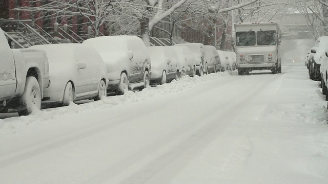 美国纽约长岛市，白雪覆盖的街道上开着送货卡车视频素材