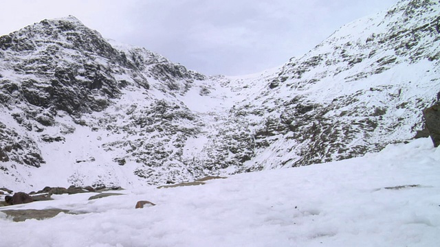 一名登山者在雪地上走向英国斯诺登尼亚的兰贝里斯山视频素材