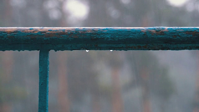 雨水滴在窗户、阳台或栏杆上，以下雨的街道为背景视频素材