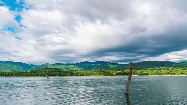 宁静的湖和波浪与热带山脉和多云的天空背景视频素材