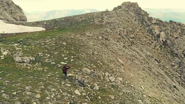 空中飞行:在山顶上绕着两个徒步旅行者飞行视频素材