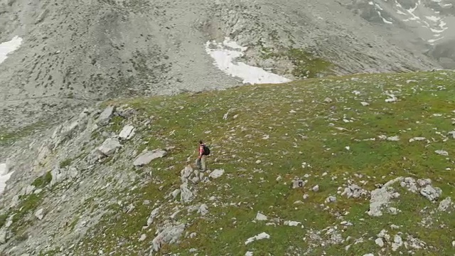 空中飞行:在山顶上绕着两个徒步旅行者飞行视频素材