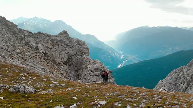 航拍:飞过山顶上几个徒步旅行者的头顶视频素材