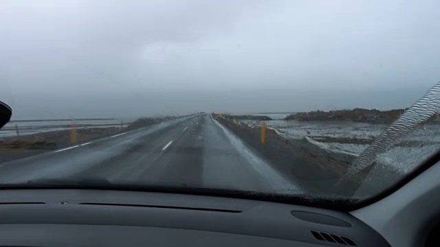 在雨中驾驶的汽车在一个空旷的道路上——乘客的观点视频素材