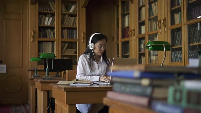 年轻的亚洲女学生在白衬衫听音乐视频素材