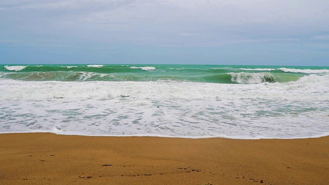 慢镜头，海浪正慢慢地拍打着热带沙滩视频素材