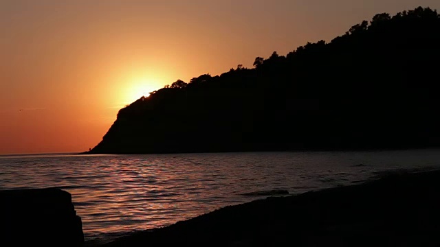 海浪轻轻地冲刷着海滩，当太阳开始落山时，海浪就向后退了视频下载