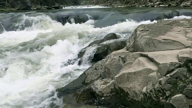 清澈的河水流淌着白色透明的泡沫和水花。视频素材