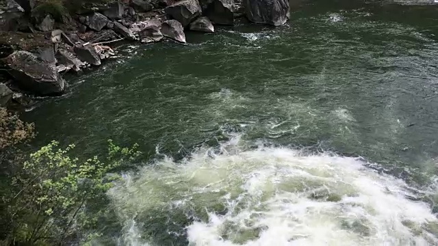 清澈的河水流淌着白色透明的泡沫和水花。视频素材