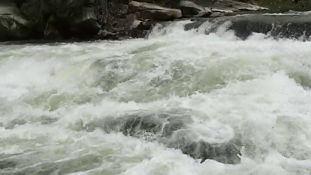 清澈的河水流淌着白色透明的泡沫和水花。视频素材