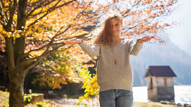 年轻女子在户外享受秋天，背景是湖和山视频素材