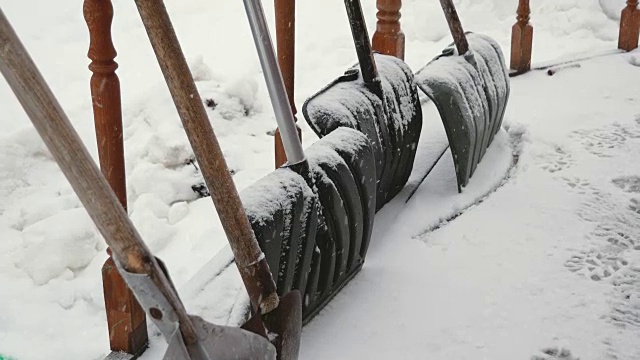 冬天大雪时，许多铁铲站在门廊上视频素材