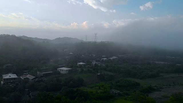 航拍的乡村村庄和高加索山脉在夏天的早晨，日出在旷野。无人机飞越云雾。格鲁吉亚。Mestia。高加索山脉视频下载