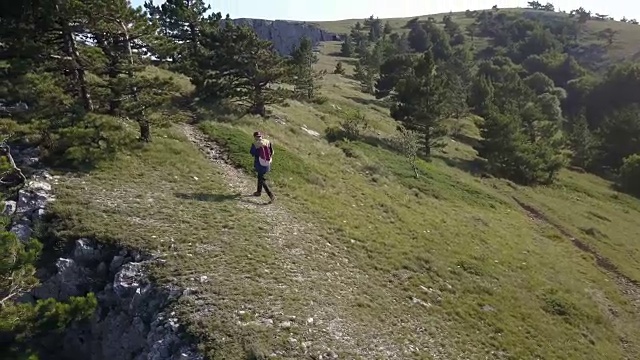 鸟瞰图的年轻人在不经意的徒步登山在一个夏天的一天视频素材