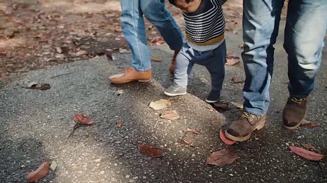 亚洲父母带着男婴在森林里散步。视频素材