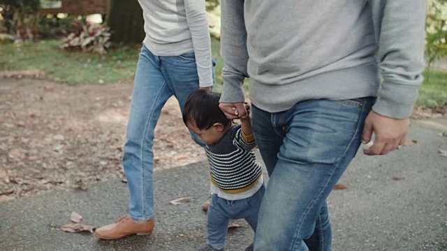 亚洲父母带着男婴在森林里散步。视频素材