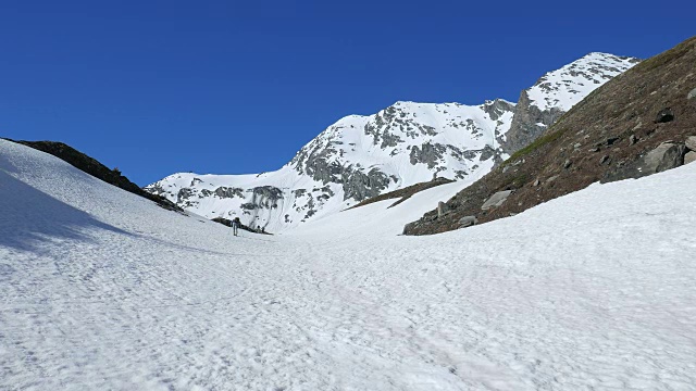 徒步者走向雪山山顶，冬季滑雪旅游活动视频素材