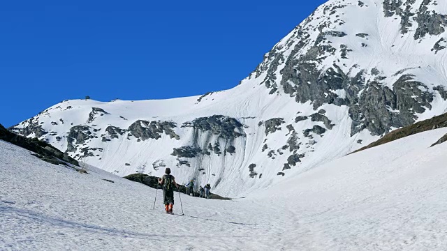 徒步者走向雪山山顶，冬季滑雪旅游活动视频素材