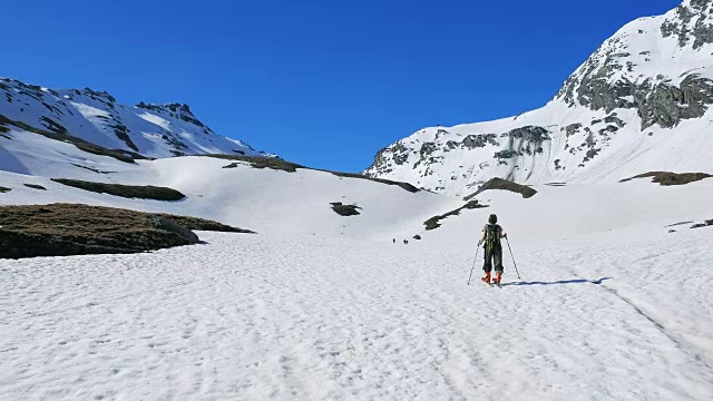 徒步者走向雪山山顶，冬季滑雪旅游活动视频素材