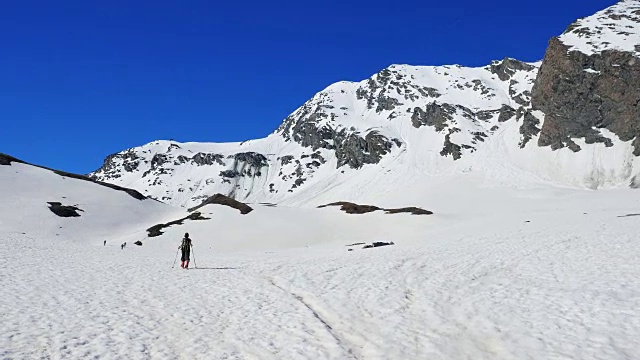 徒步者走向雪山山顶，冬季滑雪旅游活动视频素材