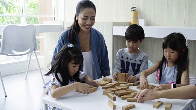 老师和小女孩、小男孩一起玩积木视频素材