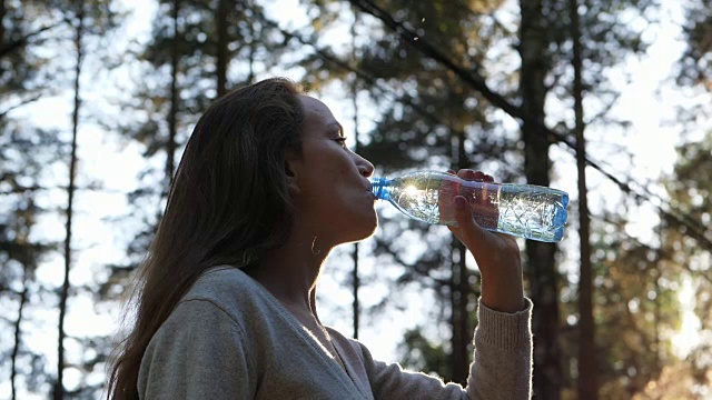 女人打开塑料瓶喝新鲜的水视频素材