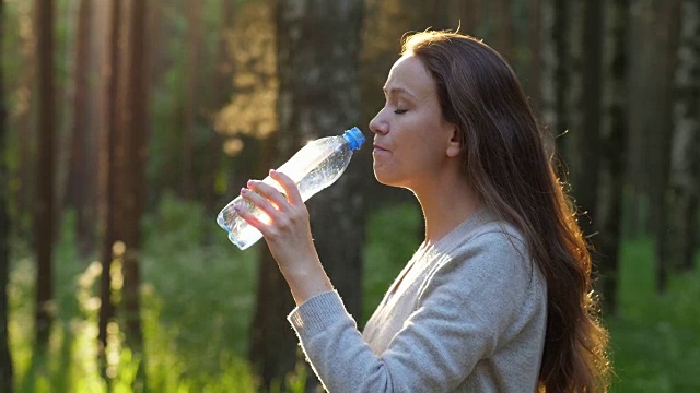 女人在公园喝淡水，慢镜头视频素材