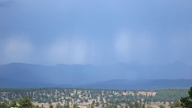 在山脉前面的巨大山谷上降雨的时间流逝视频素材