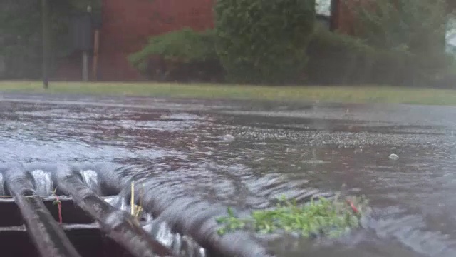 大雨落在街道上，流过下水道视频素材