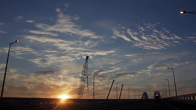 穿过正在建设中的大桥，欣赏壮观的云彩和夕阳。日落视频下载